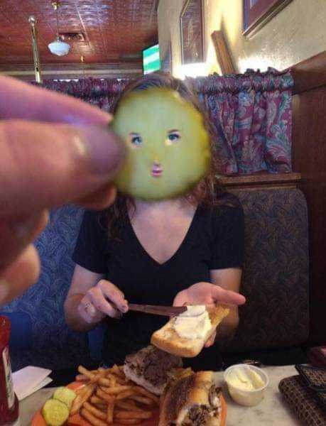 someone is eating a sandwich with a face on it