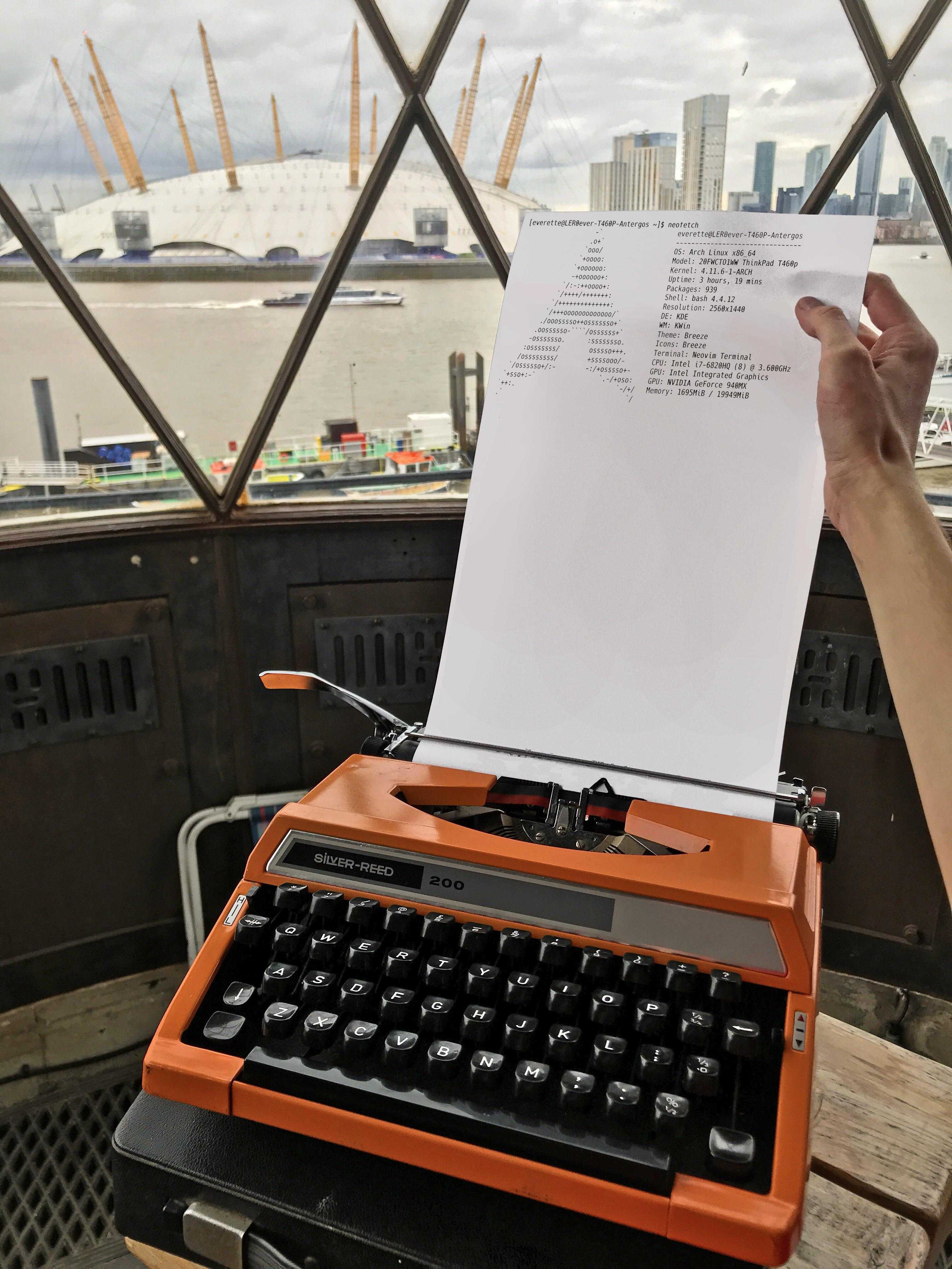 someone is holding a sheet of paper over a typewriter