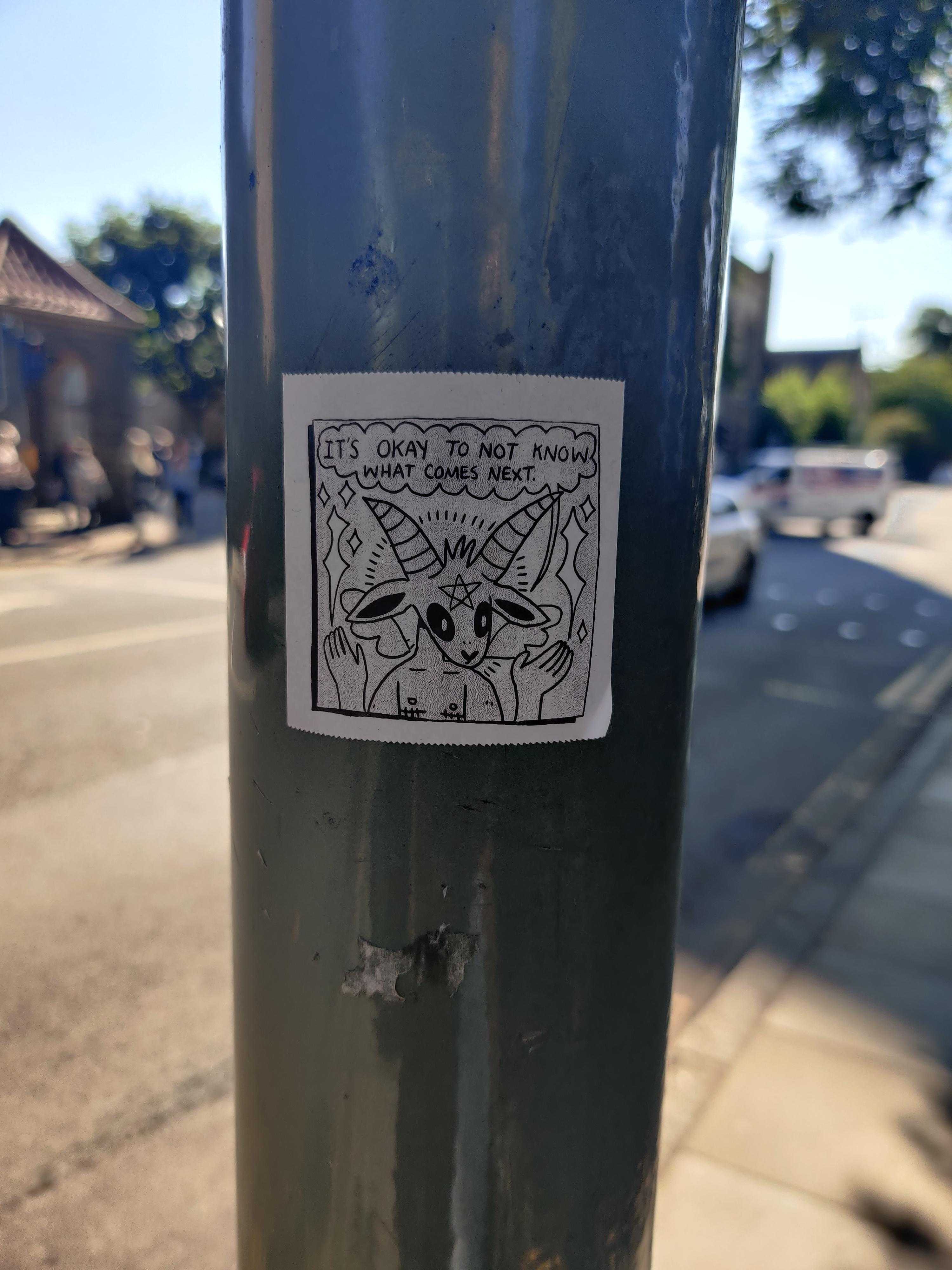 there is a sticker on a pole on the side of the street