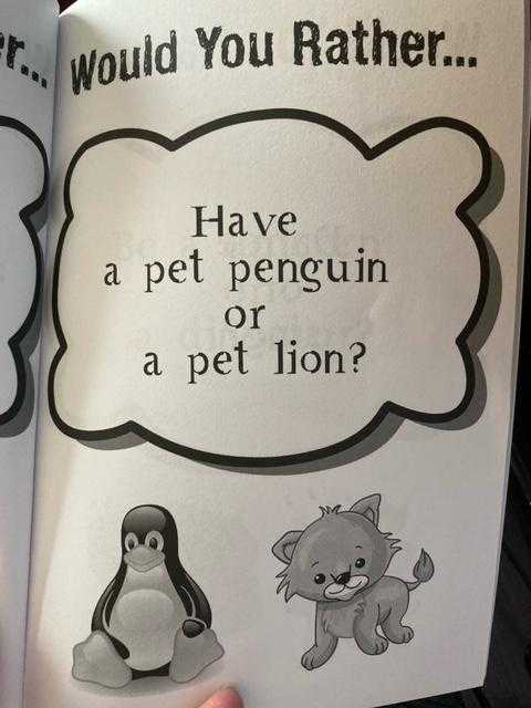 someone is holding a book with a picture of a penguin and a cat