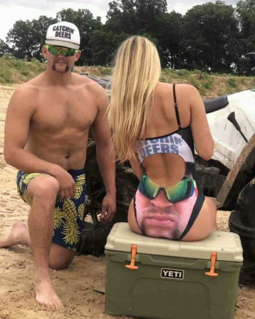 there is a man and a woman sitting on a cooler on the beach