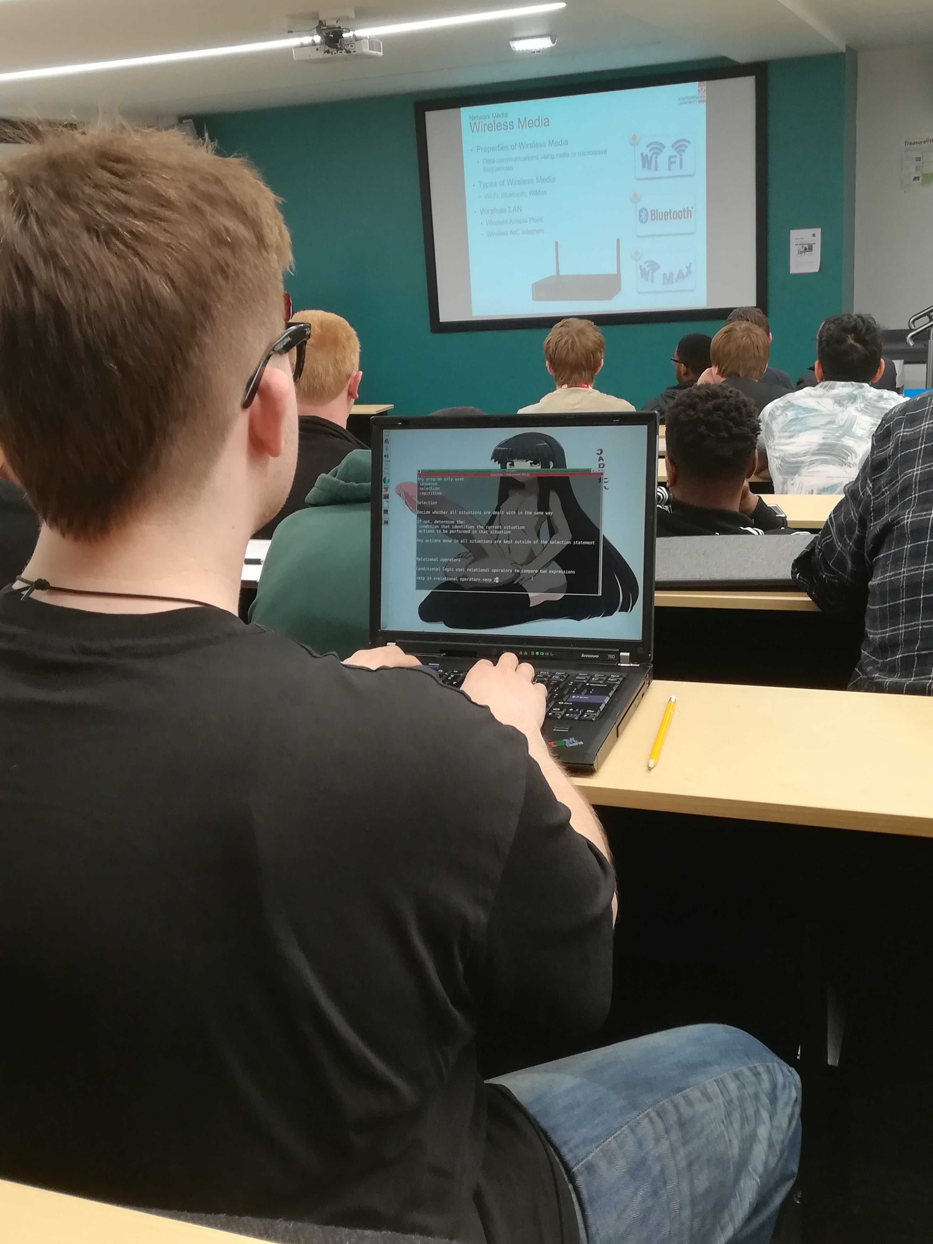 there are many people sitting at tables in a classroom with laptops