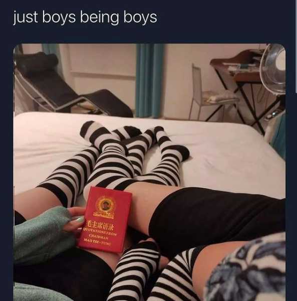 someone is reading a book on a bed with striped socks