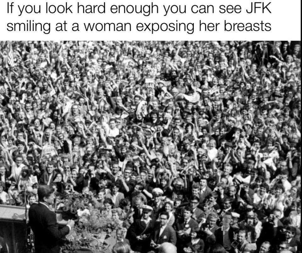 a black and white photo of a crowd of people with a man on a stage