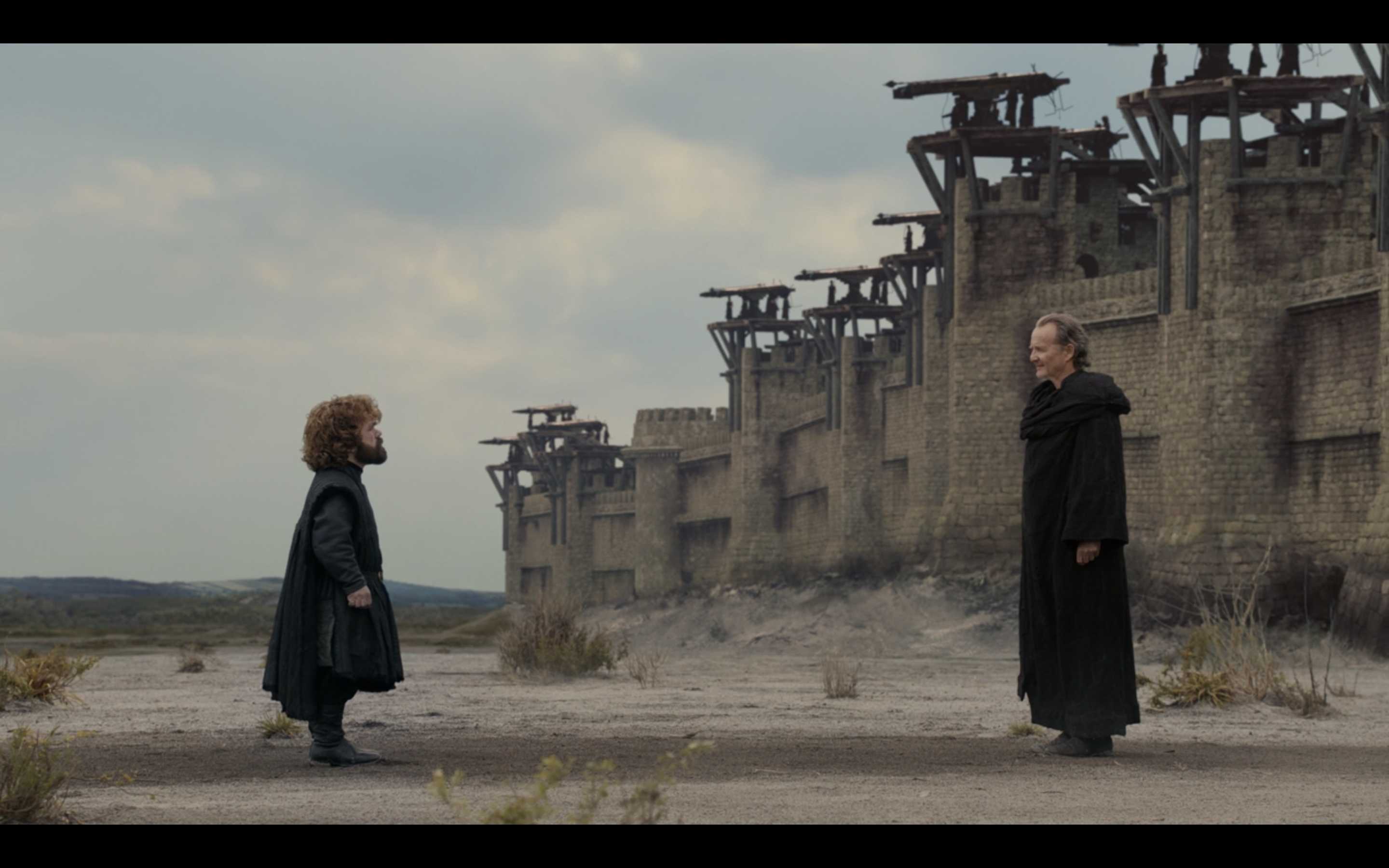 there are two people standing in front of a building in the desert