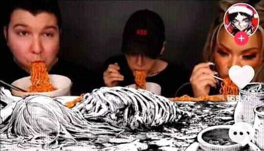 there are two people eating spaghetti with a cat on the table