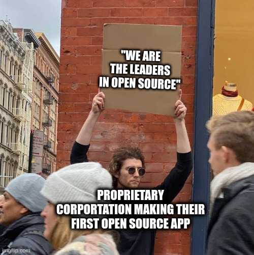 people holding up a sign in front of a building with a sign that says we are the leaders in open source proprietary corporation making their first open source app