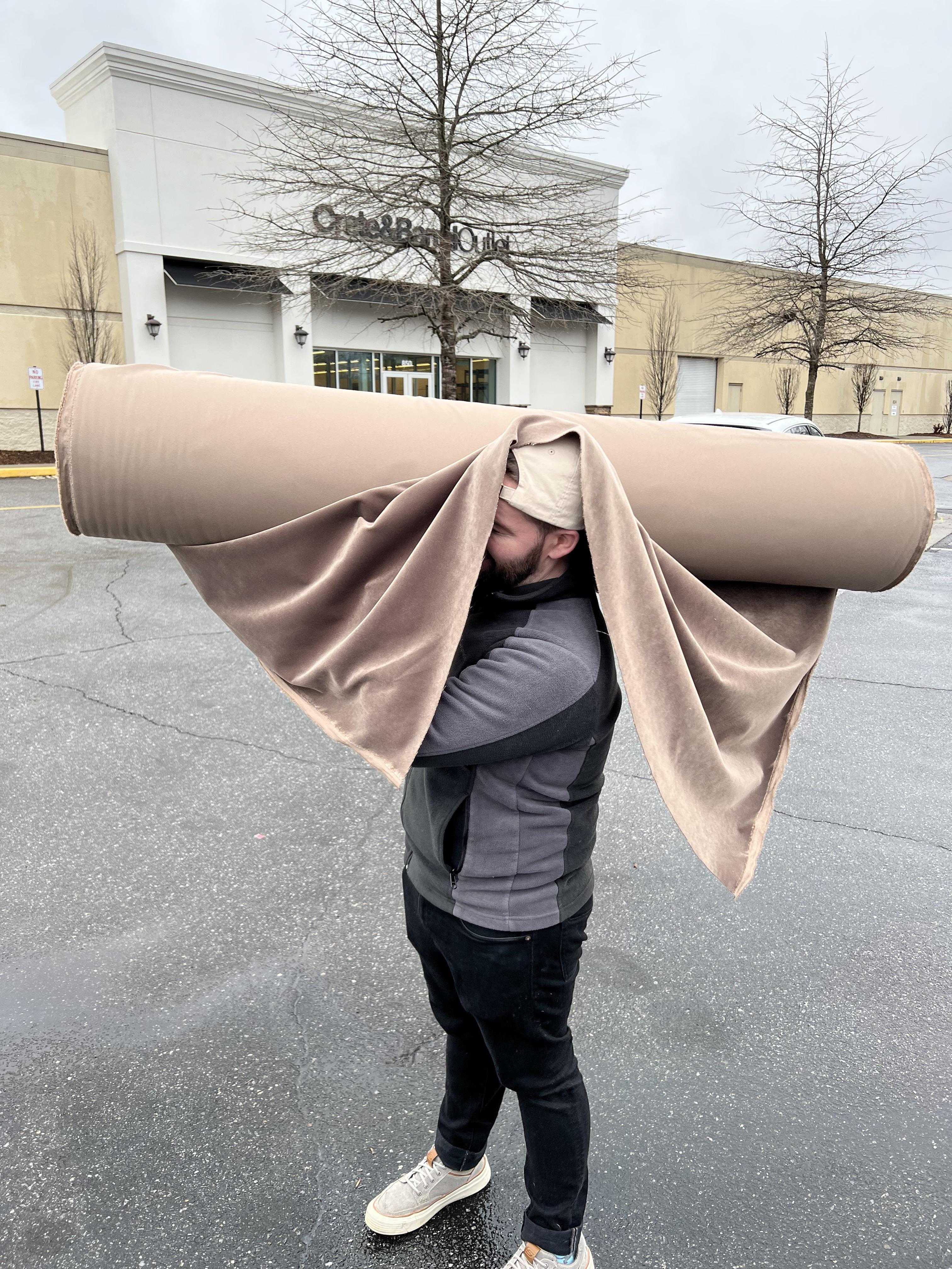 man carrying a roll of toilet paper on his head