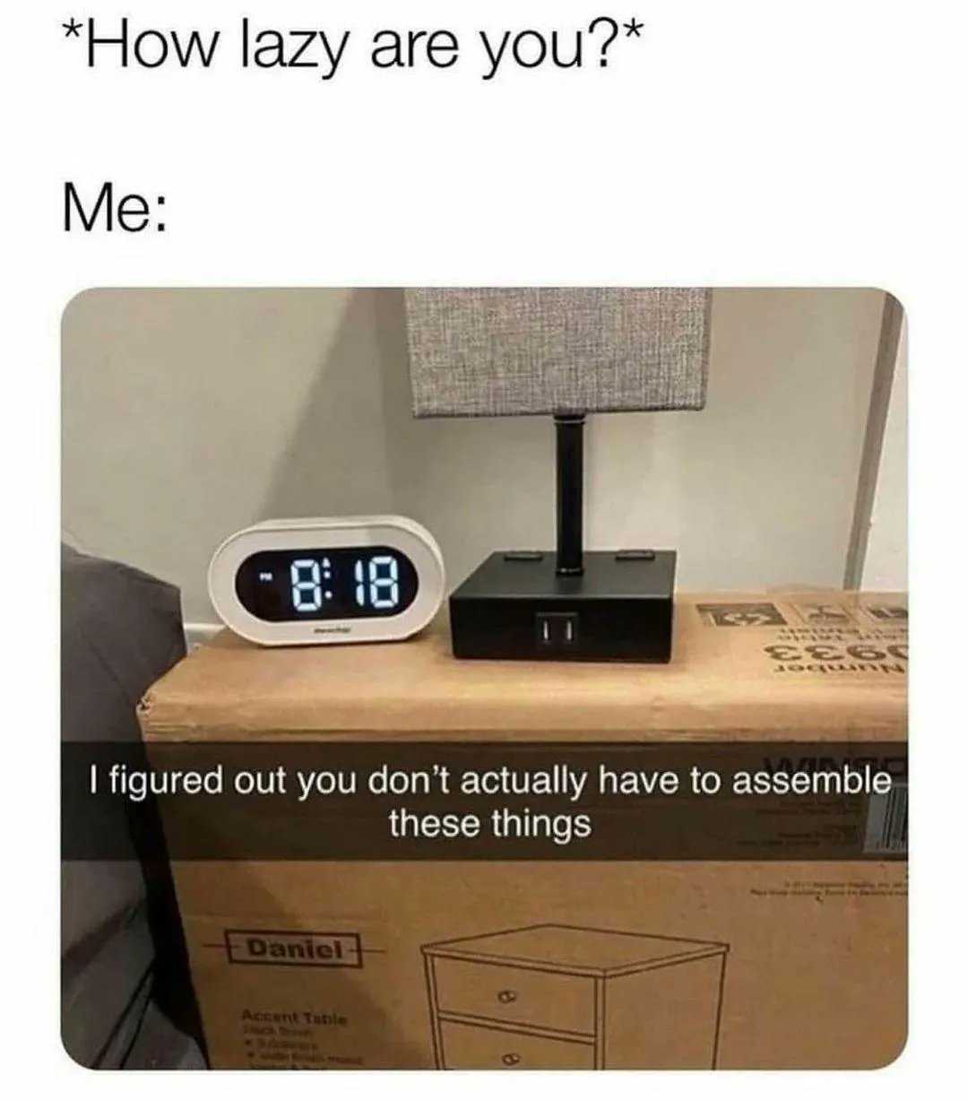 alarm clock on a table with a box and a lamp