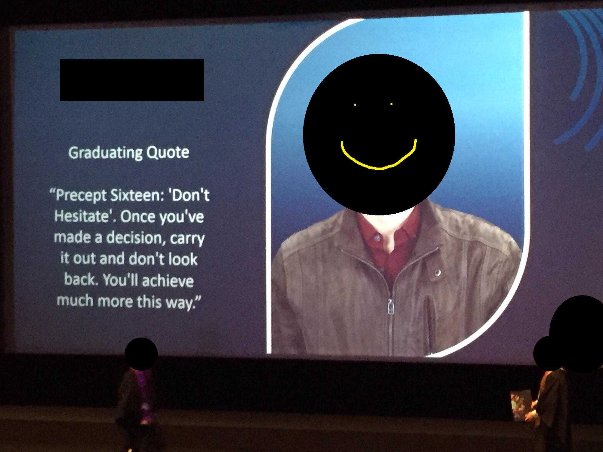 there is a man standing in front of a projection screen with a smiley face on it