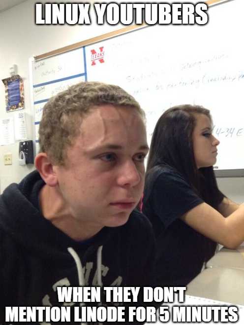 guy in a black shirt sitting at a desk with a whiteboard