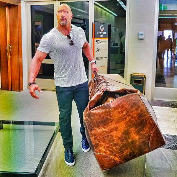 araffe man with a large brown bag walking through an airport