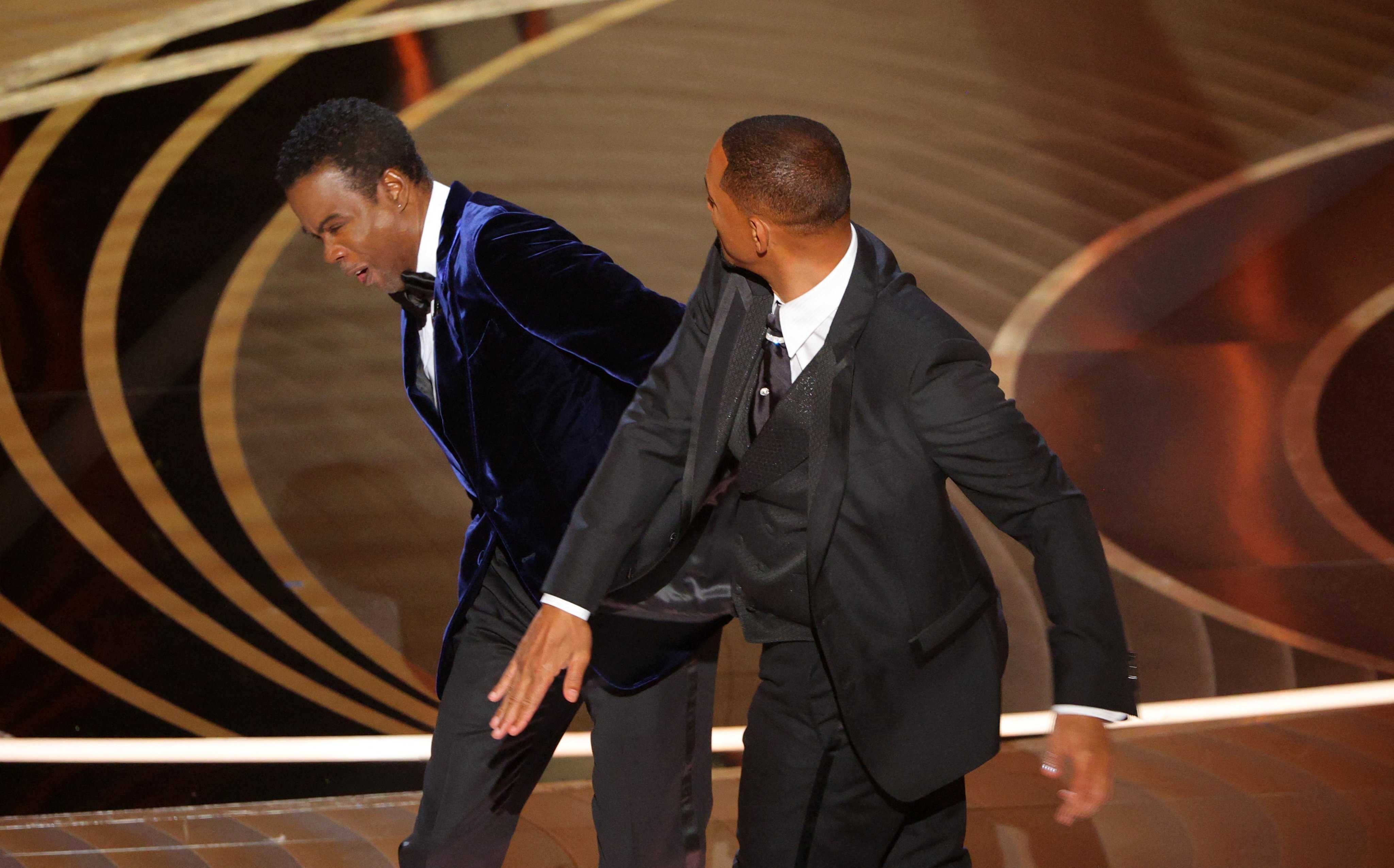 two men in suits are dancing on stage at an event