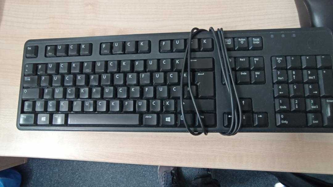 there is a keyboard and mouse on a desk with a cord