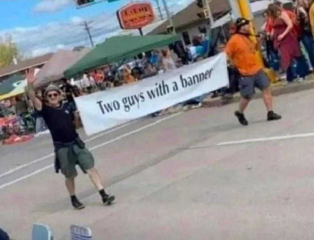 there are two guys with a banner on the street