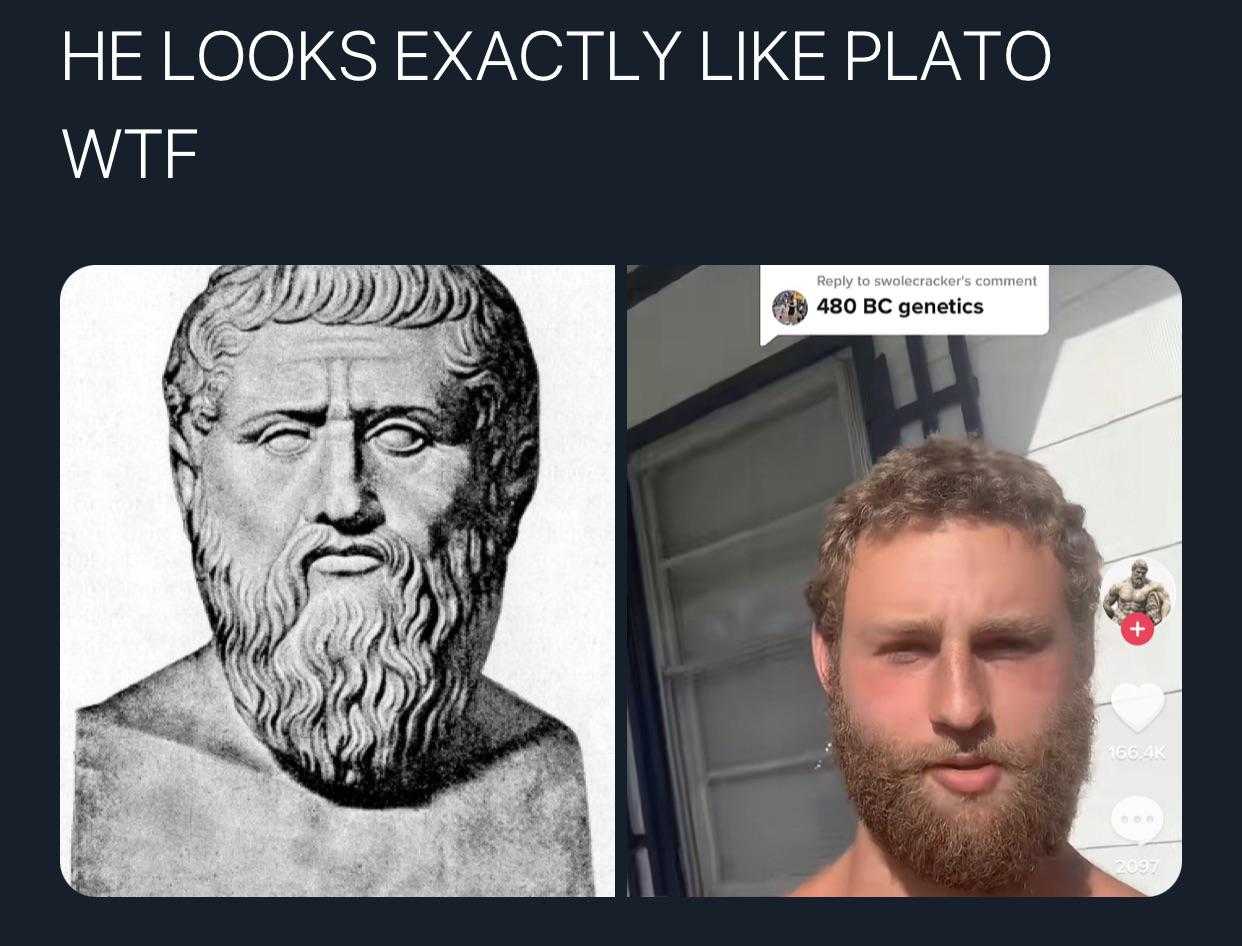 man with beard and beardlock in front of a statue of a man