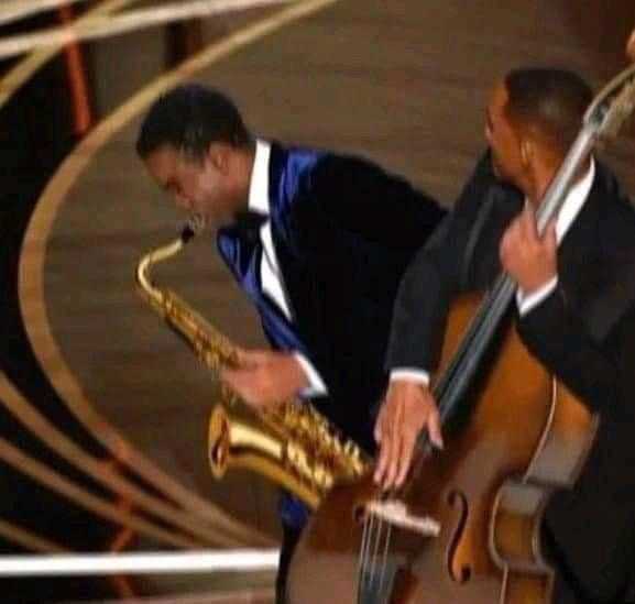 there are two men playing instruments on stage at an event