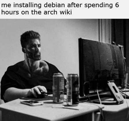 man sitting at a desk with a computer and drinking a can of water