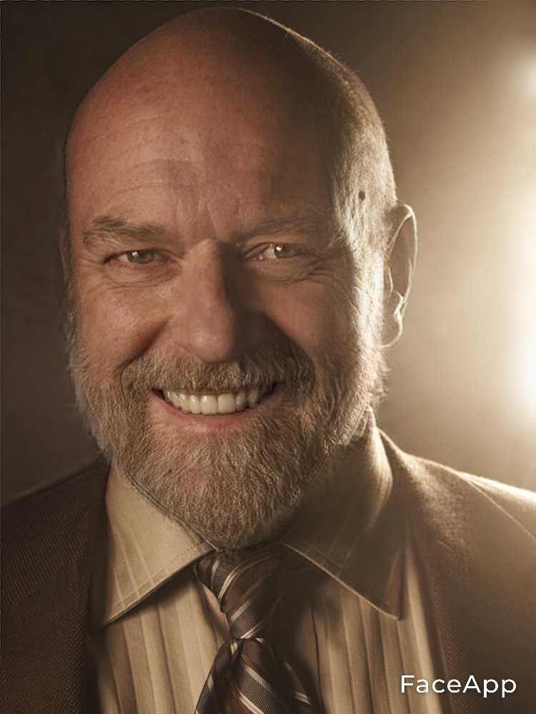 man with a beard and a suit smiling for a picture