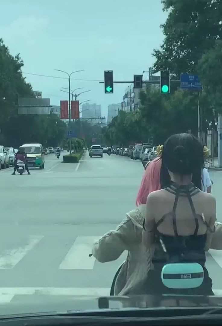 there is a woman riding a motorcycle with a dog on the back