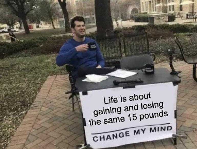 man sitting at a table with a sign on it