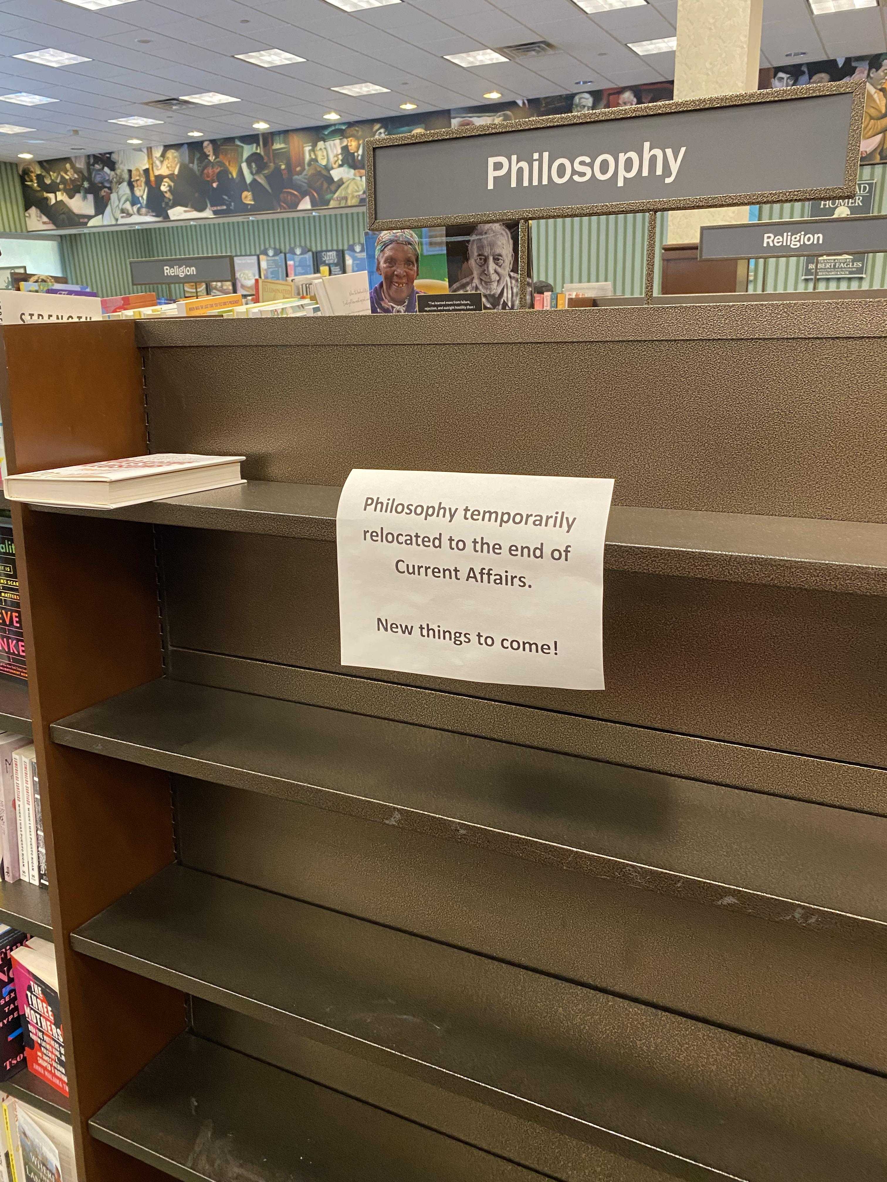 there is a sign on the shelf in a bookstore reading