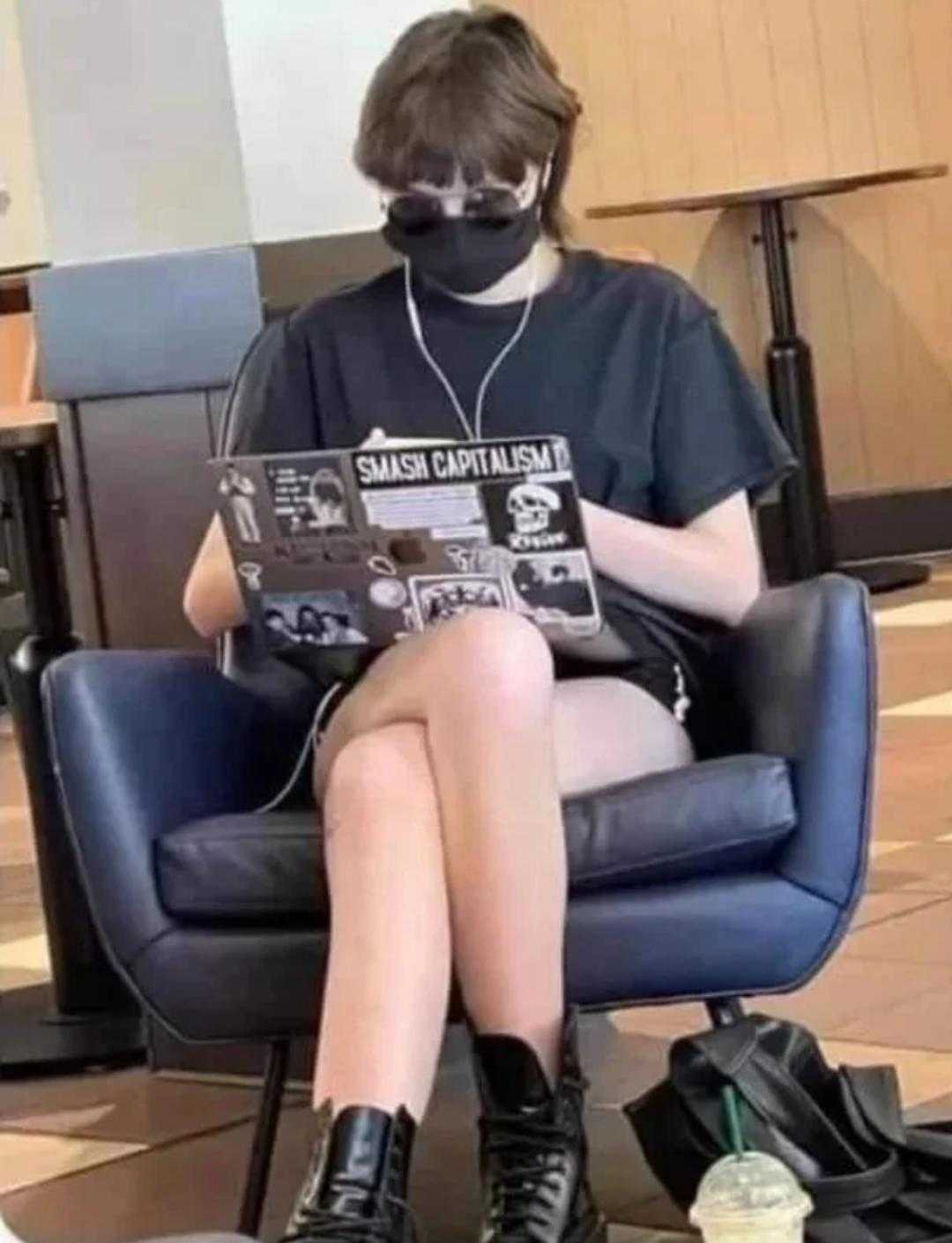 araffe sitting in a chair with a laptop and a mask on