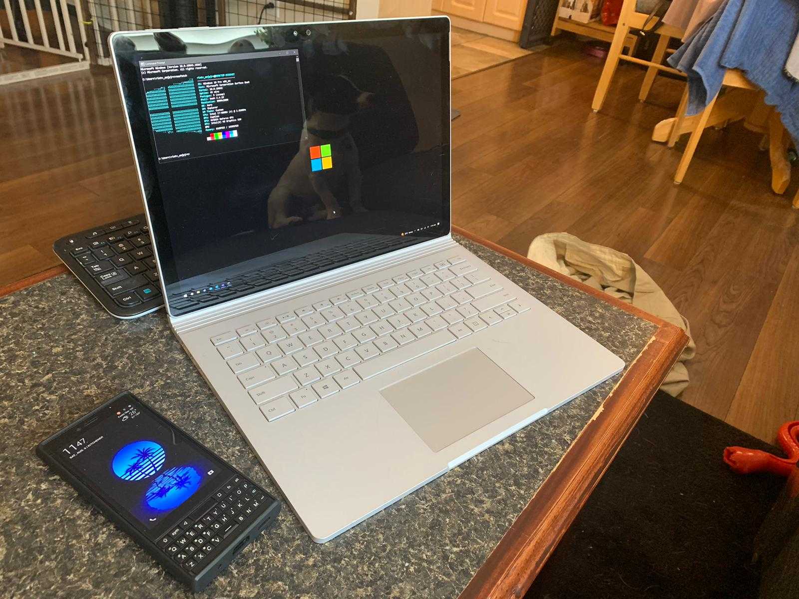 laptop and cell phone on a table with a wooden table top