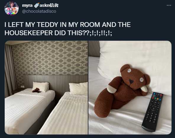 teddy bear sitting on a bed next to a remote control