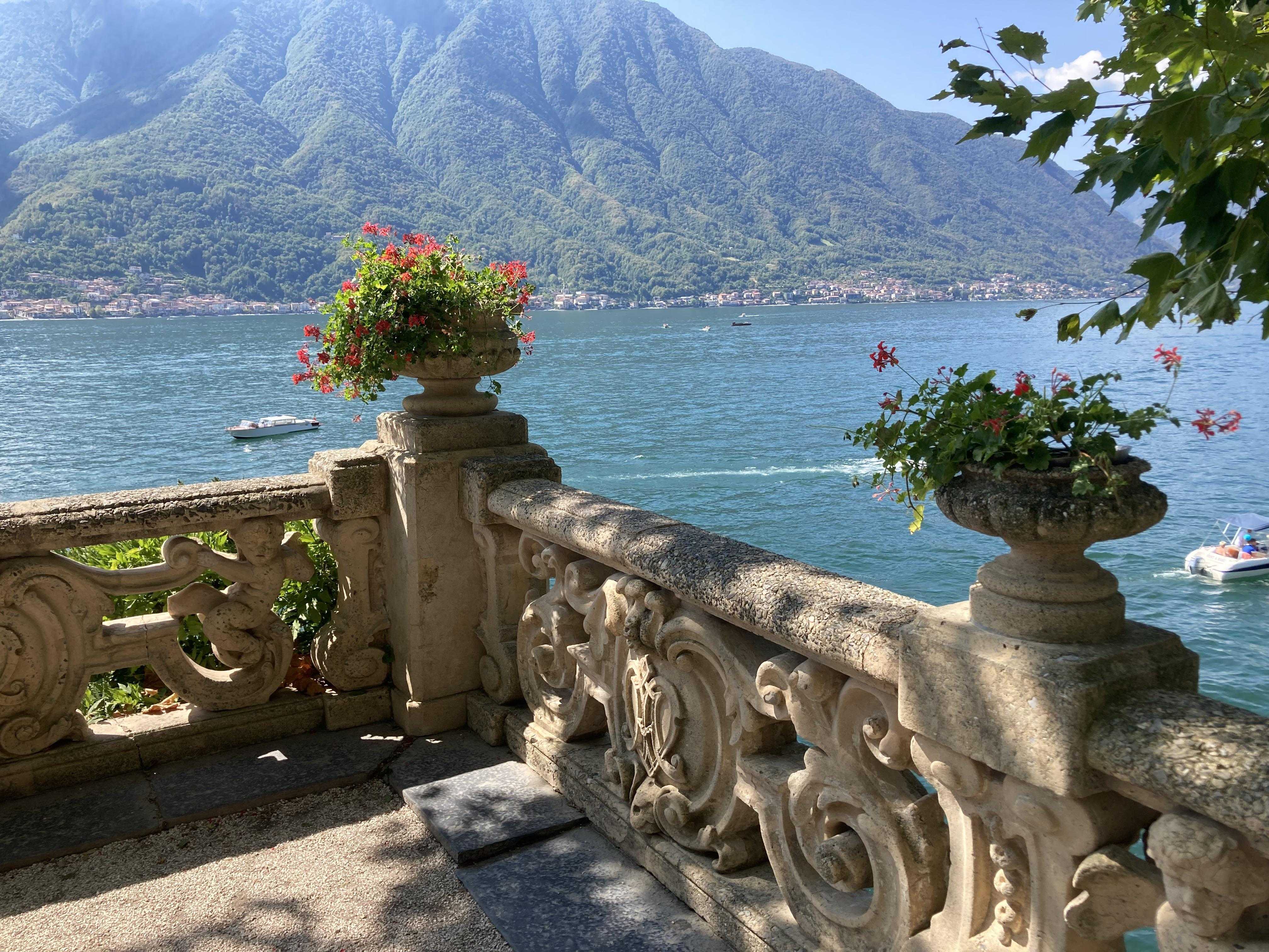 there is a stone fence with a vase of flowers on it