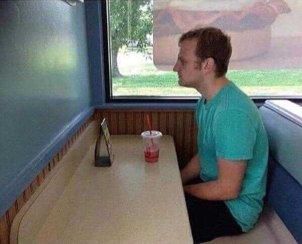 there is a man sitting at a table in a booth