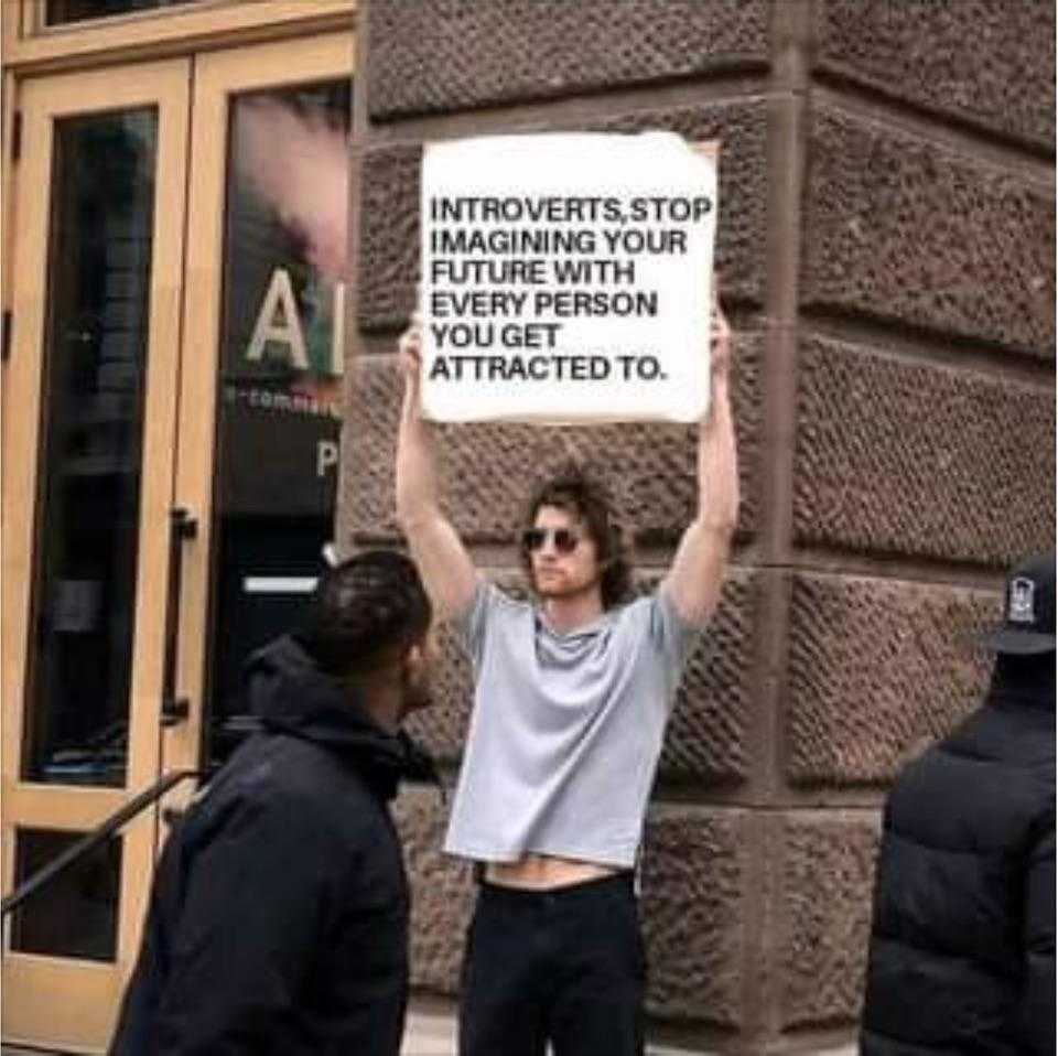 man holding up a sign in front of a building