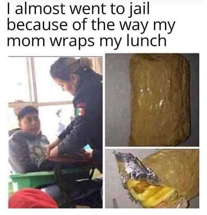 kid sitting at a table with a sandwich in front of him