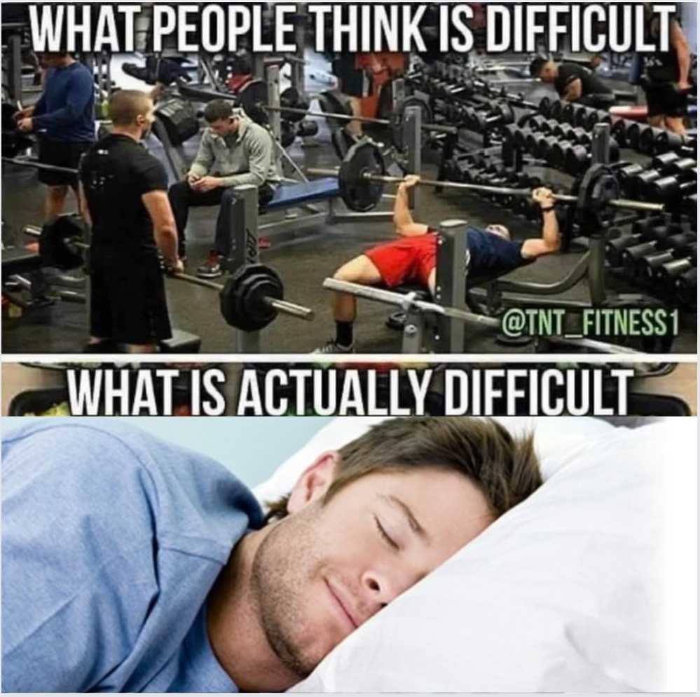 there is a man sleeping in a gym with a barbell