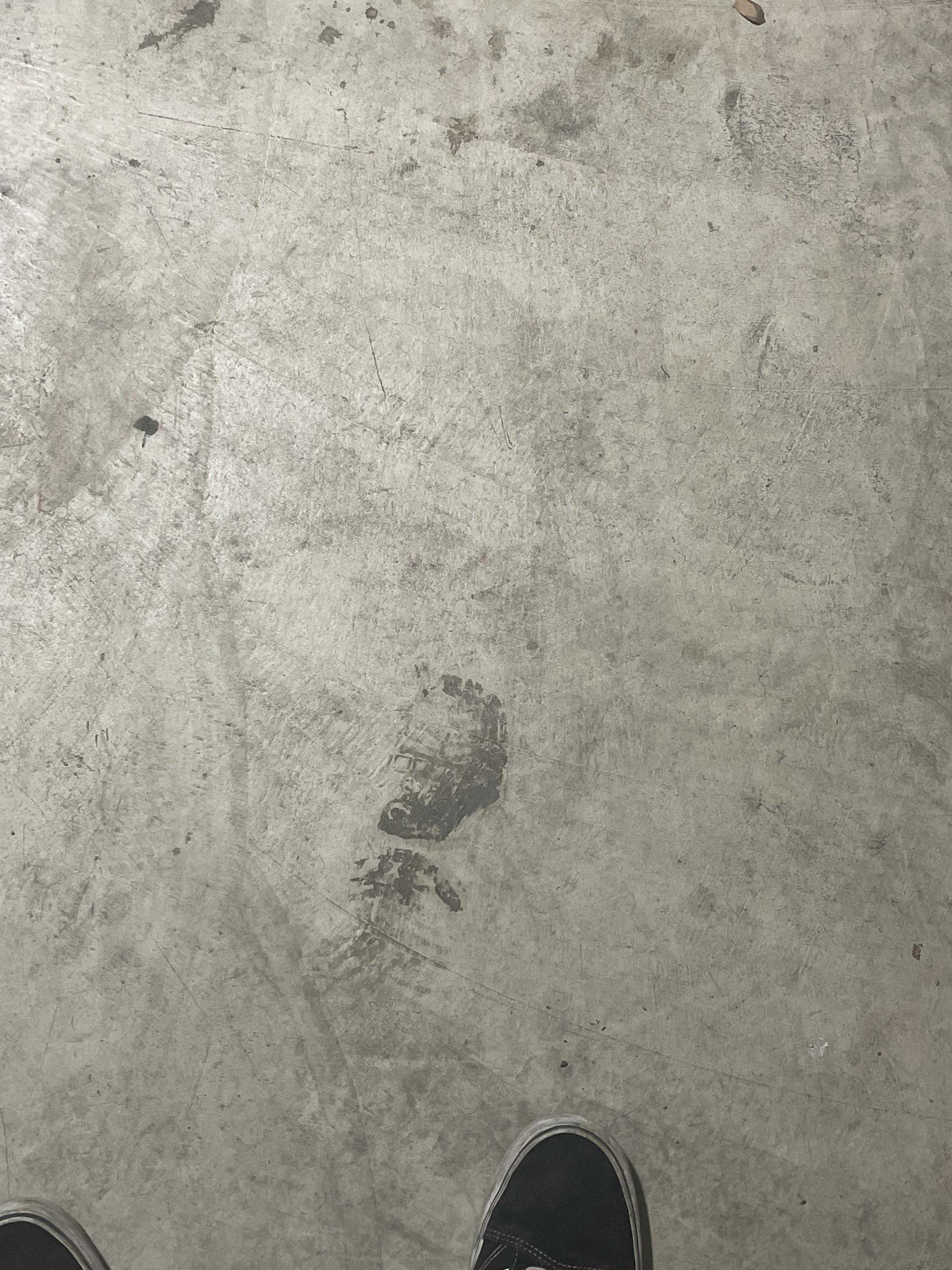 someone standing on a concrete floor with their feet on the ground