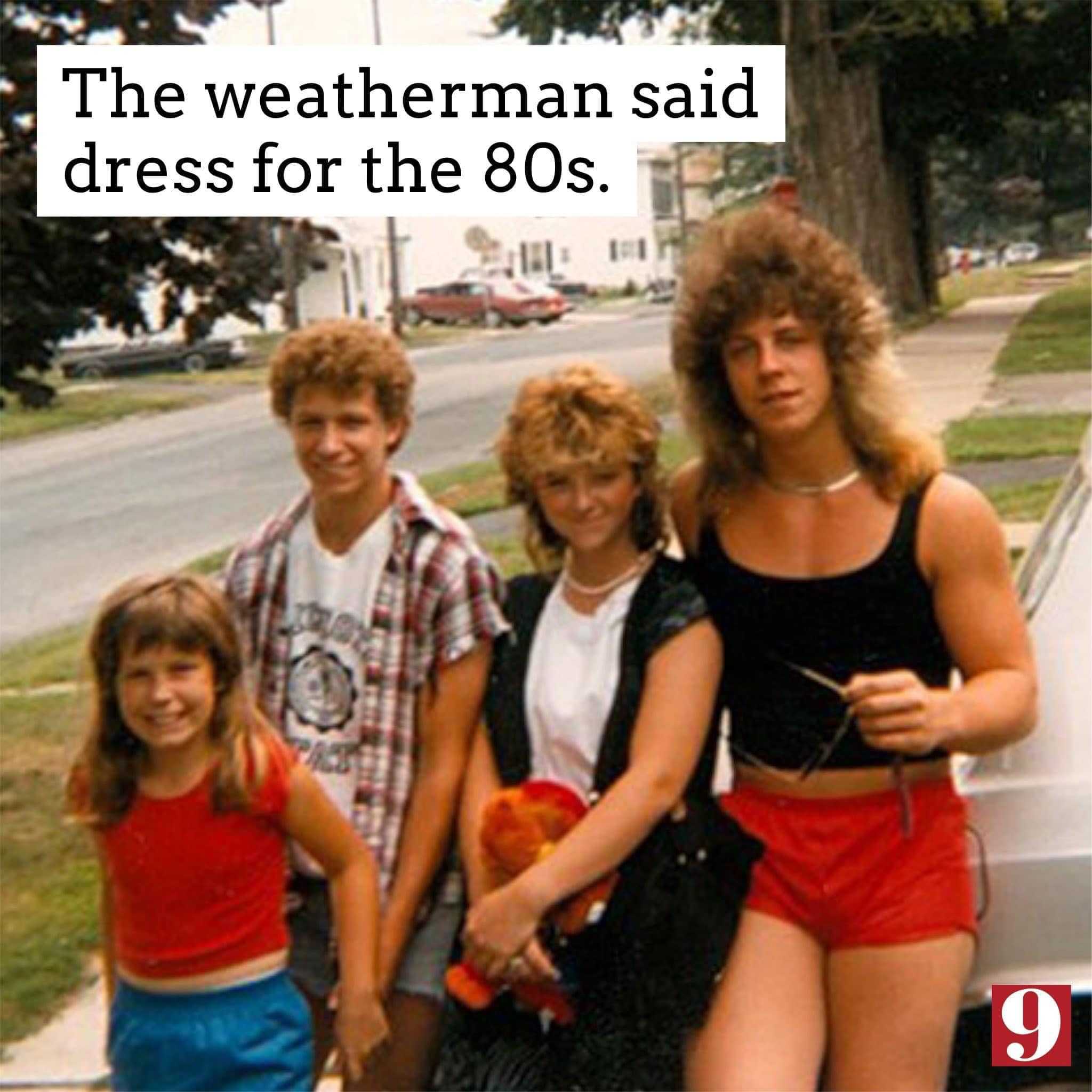 there are three people standing next to a car on the street