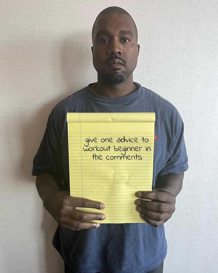 man holding up a yellow sign with a note attached to it