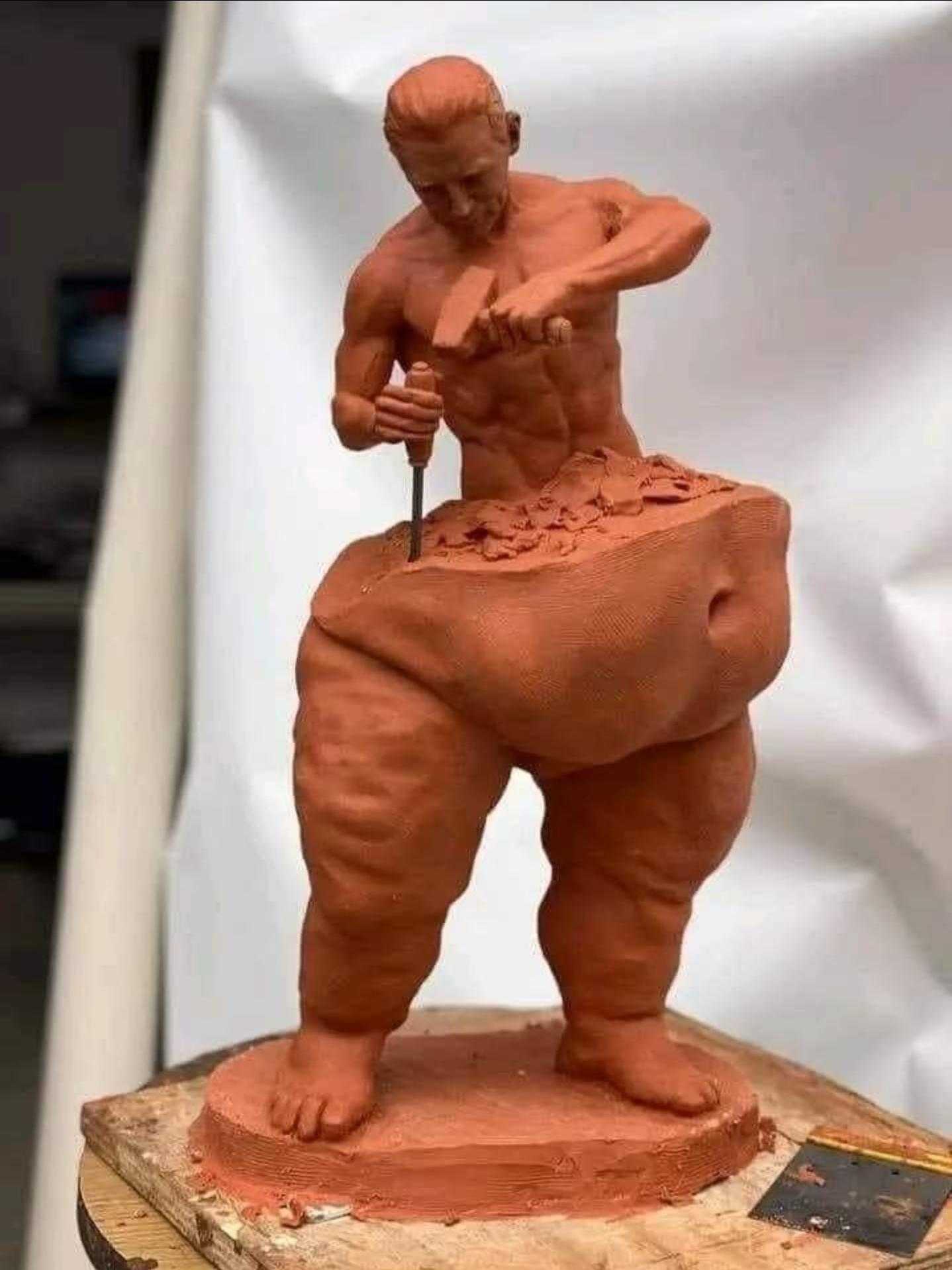 a close up of a clay sculpture of a man holding a stick