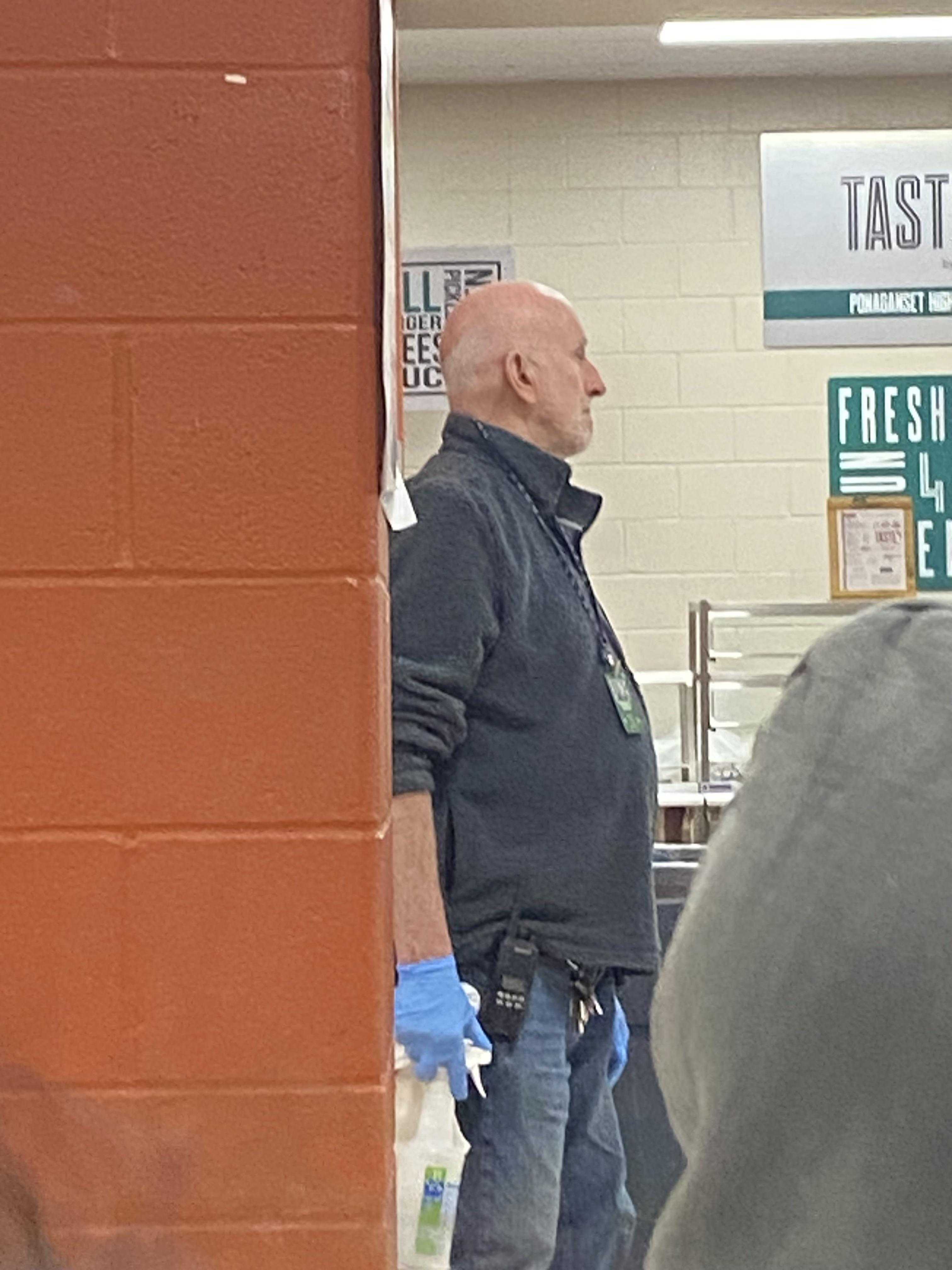 there is a man standing in a kitchen with a sign on the wall