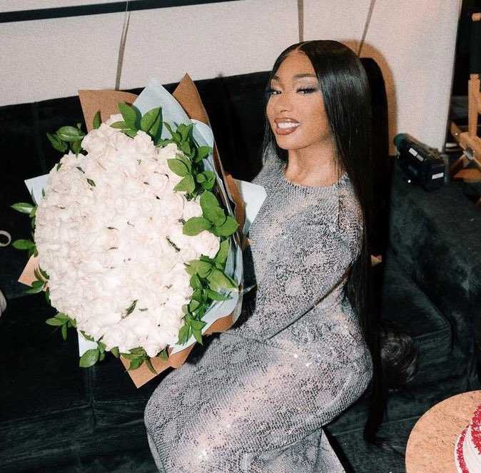 there is a woman sitting on a couch holding a bouquet of flowers